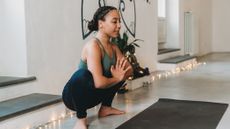 woman squats during yoga practice