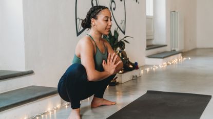woman squats during yoga practice