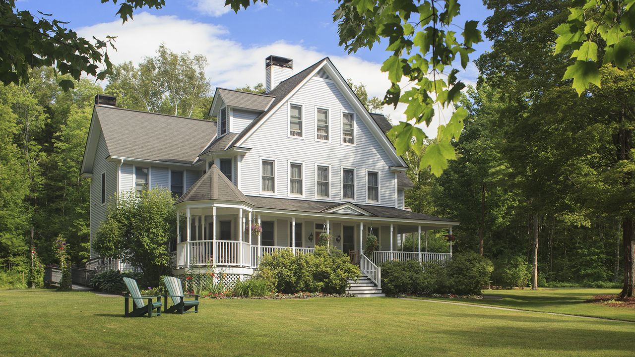 Front garden ideas – Victorian farmhouse home with lawn and large front porch in summer