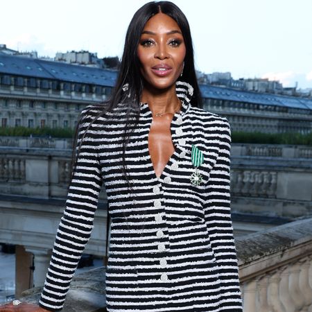 Naomi Campbell with long straight hair wearing a black and white striped dress. 