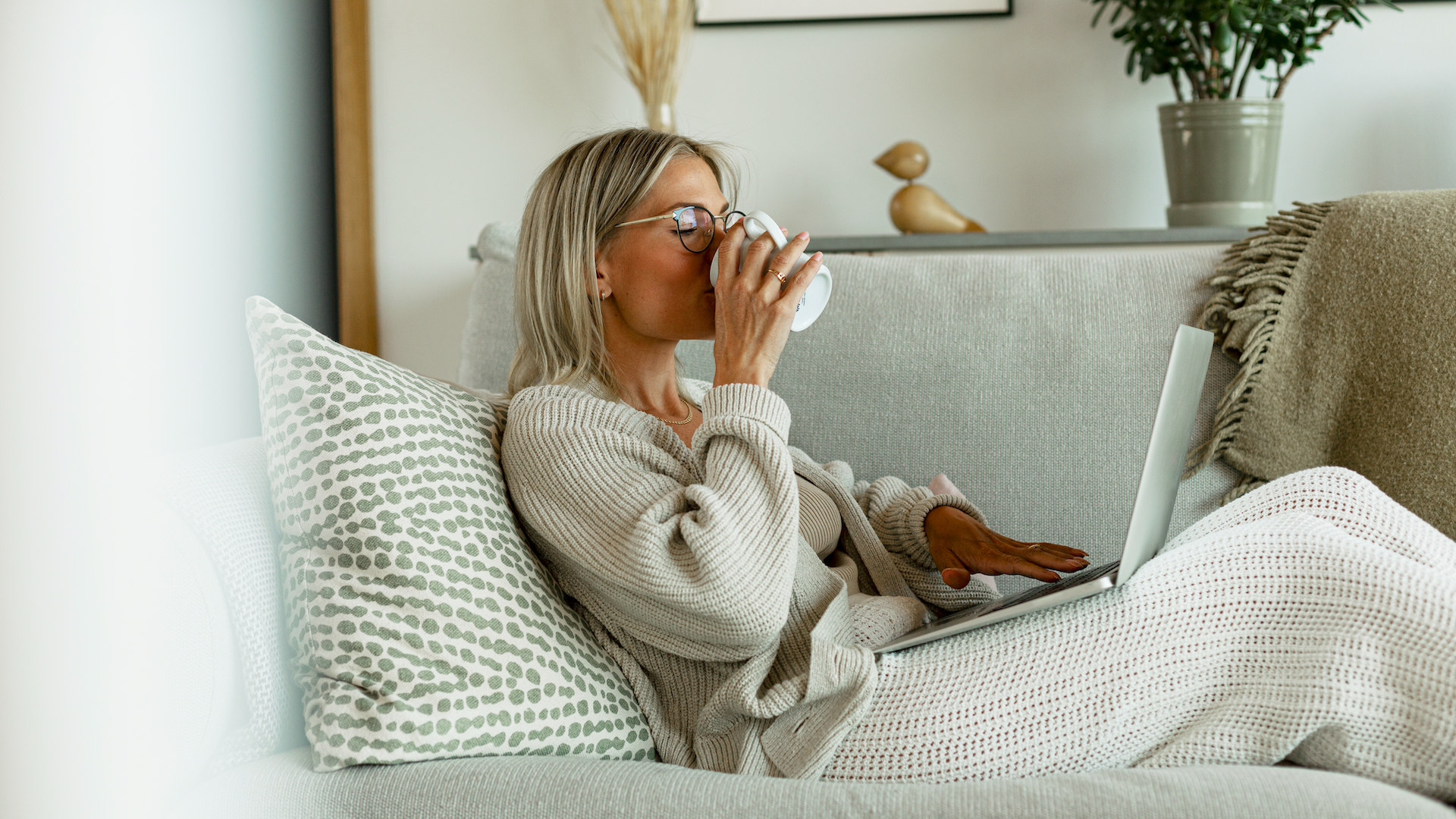 Woman sat on sofa using laptop