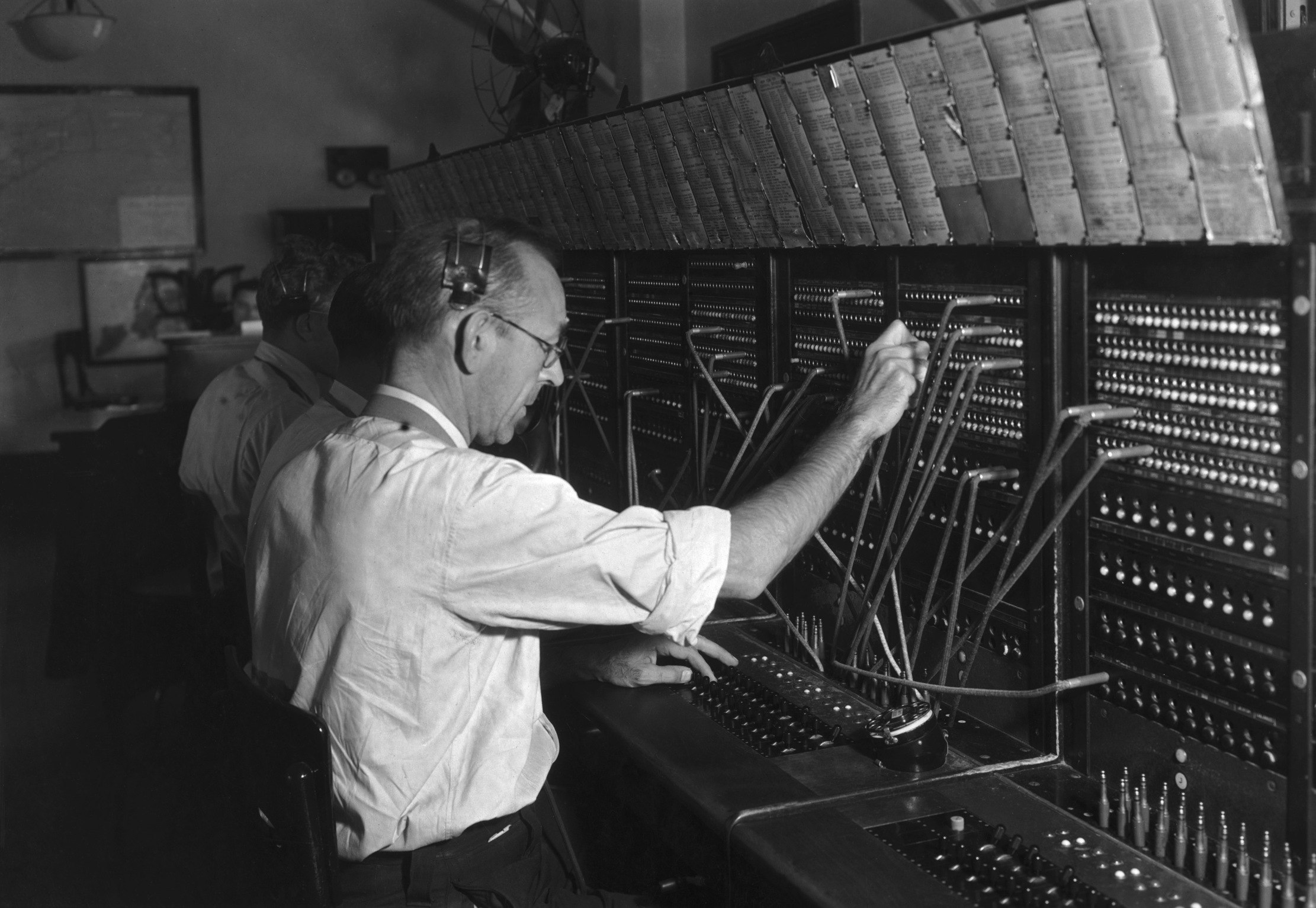 Switchboard operators handling non-emergency calls to the police, circa 1950.