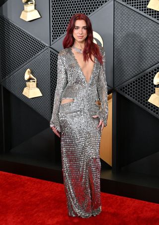 Dua Lipa attends the 66th GRAMMY Awards at Crypto.com Arena on February 04, 2024 in Los Angeles, California wearing a silver dress with pelvic cut-outs