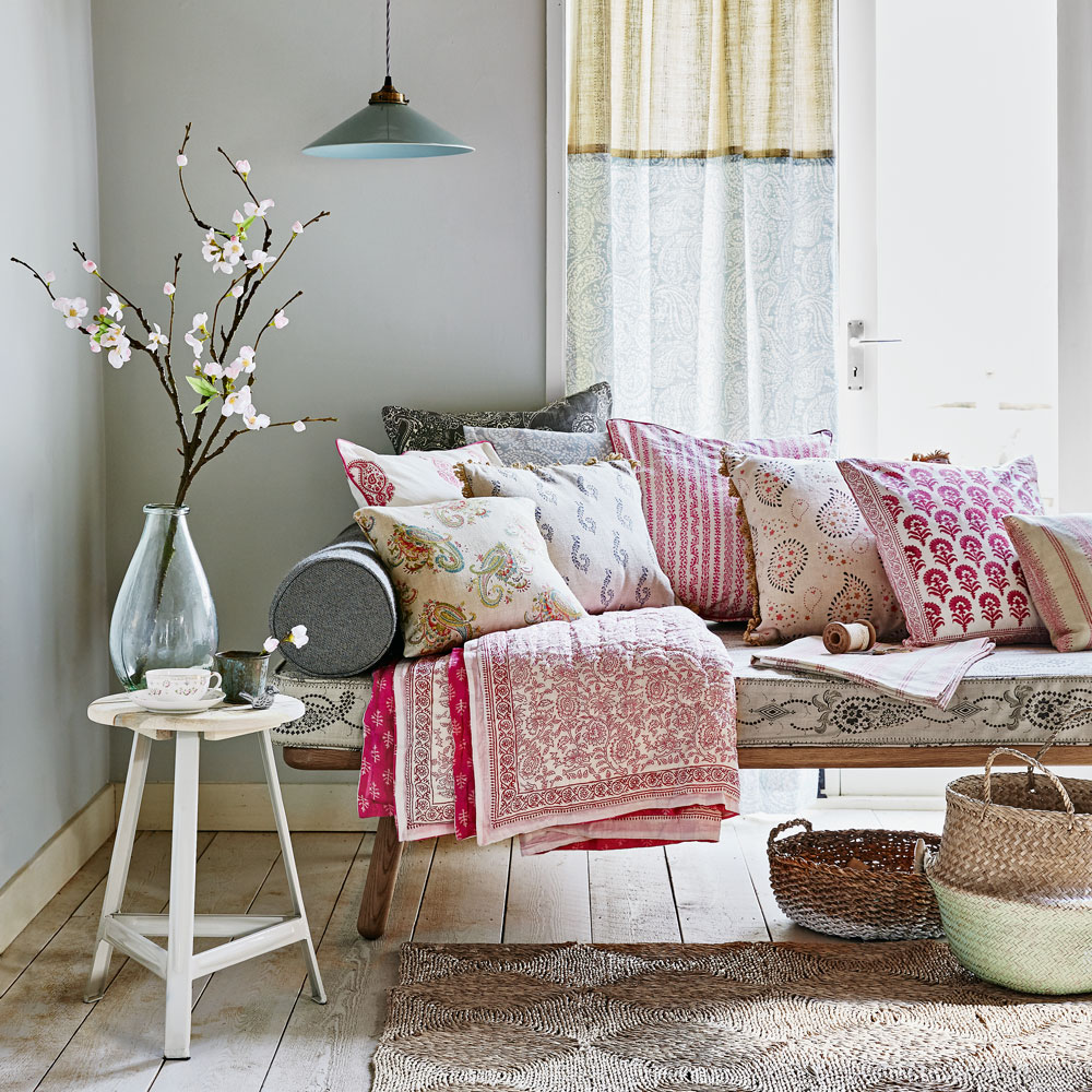 Day bed in room on wooden floor with pillows and other decor