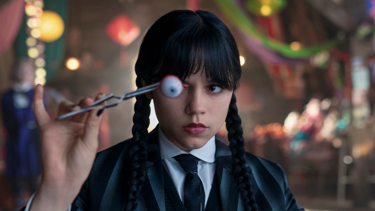 Wednesday holding eyeball up to her face in Wednesday Season 2