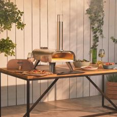 Vonhaus pizza oven in promotional image on table in garden 
