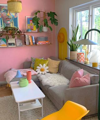 A colorful living room with a gray couch, colorful cushions, and decorated shelves