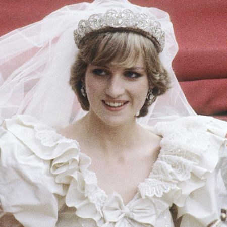 Princess Diana rides in a carriage following her wedding to Prince Charles, while wearing a voluminous wedding gown and long veil with the Spencer tiara, and Kate Middleton wears a lace white wedding gown with a tiara and veil as she marries Prince William