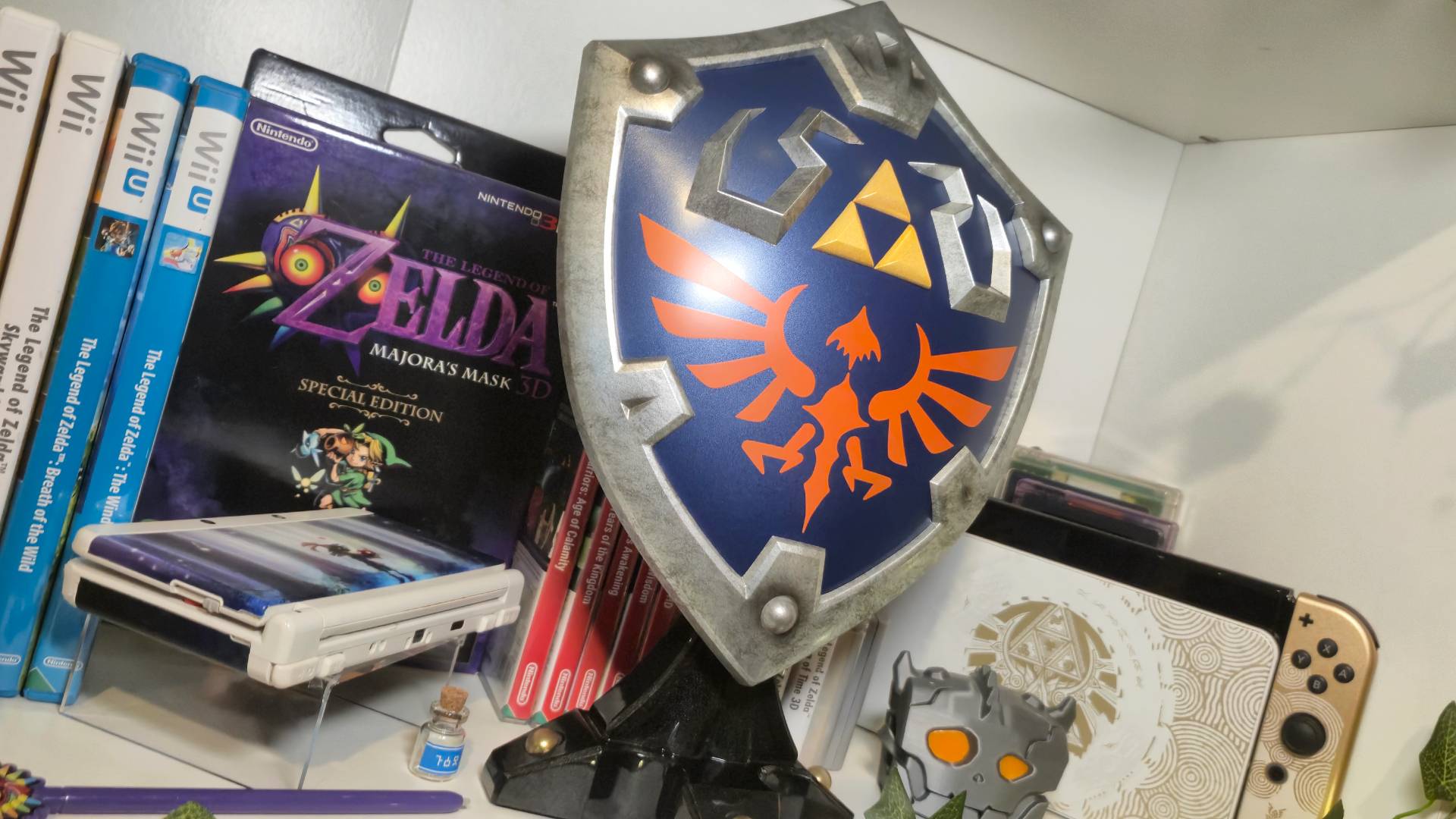 Photo of the F4F Hylian Shield sitting in front of a series of Legend of Zelda games.