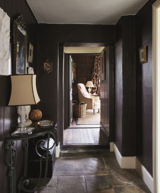 farmhouse hallway with dark brown walls and stone floor