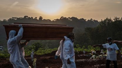 Grave diggers bury a coffin in Semarang, Java