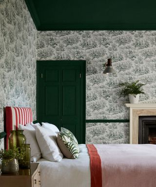 wallpapered bedroom with dark green ceiling and woodwork
