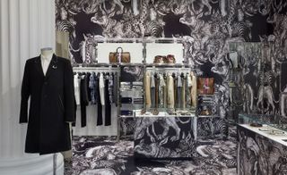 Louis Vuitton menswear pop-up shop in Selfridges with clothing displays and walls with African animals painted on them.