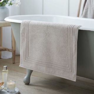 Bath mat on the side of a roll top bath