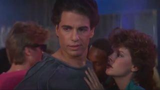 Chris Sarandon shows a look of disdain on the dance floor while Amanda Bearse clings to him in Fright Night (1985).