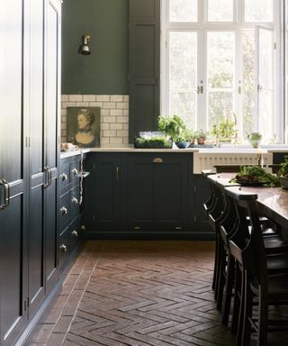 Dark green kitchen by deVOL with brick floors