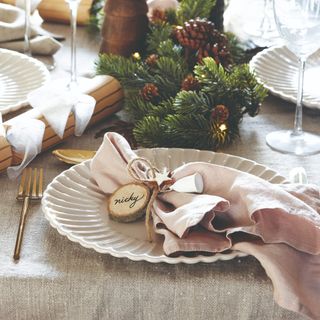 A set Christmas-decorated table with a cloth napkin