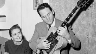 CIRCA 1952: Husband and wife songwriting duo Les Paul & Mary Ford perform on electric guitar and piano at a Capitol Records microphone in circa 1952