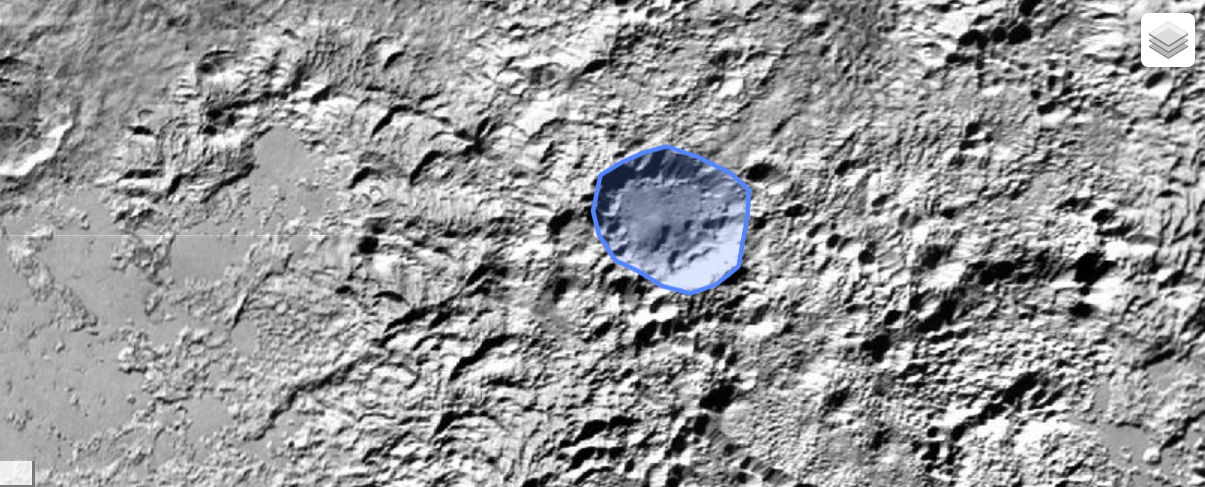 A gray image of the surface of Pluto, showing craters and impacts with a shaded blue oval where the Kiladze crater is