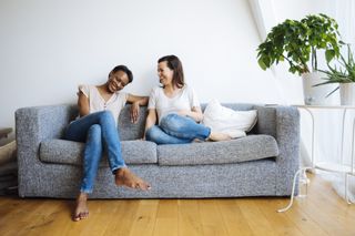 Can you be friends with your partners ex? Two happy relaxed women sitting on couch at home
