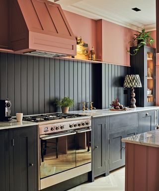 Grey kitchen with wall panels and red painted extractor fan
