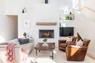 A living room layout idea by Mountain Mod with cream leather and brown leather sofas, wooden coffee table, modern cassette fireplace and TV in alcove