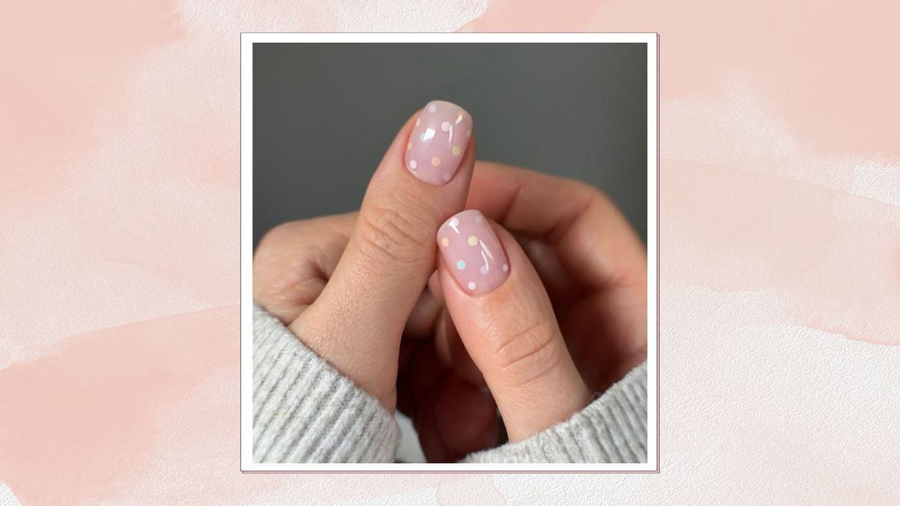 A pink frame containing an image of a woman&#039;s thumbs, painted with pink polka dot BIAB nails