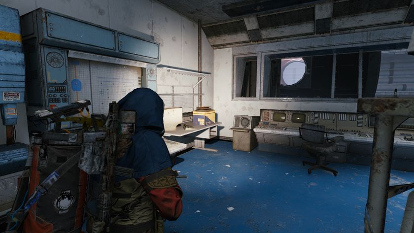 Arc Raiders On Deaf Ears: A player looking at a cluttered desk inside an office in the Assembly Workshops area of Stella Montis, using a torch to light it up.