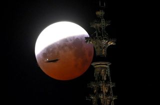 Photographer Henning Kaiser captured this amazing view of the partly eclipsed blood moon rising behind a tower of the Cologne Cathedral in Cologne, North Rhine-Westphalia, Germany, just as an airplane passes by, on Jan. 21, 2019.