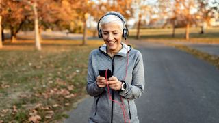 Woman listening to music on phone wearing wired headphones