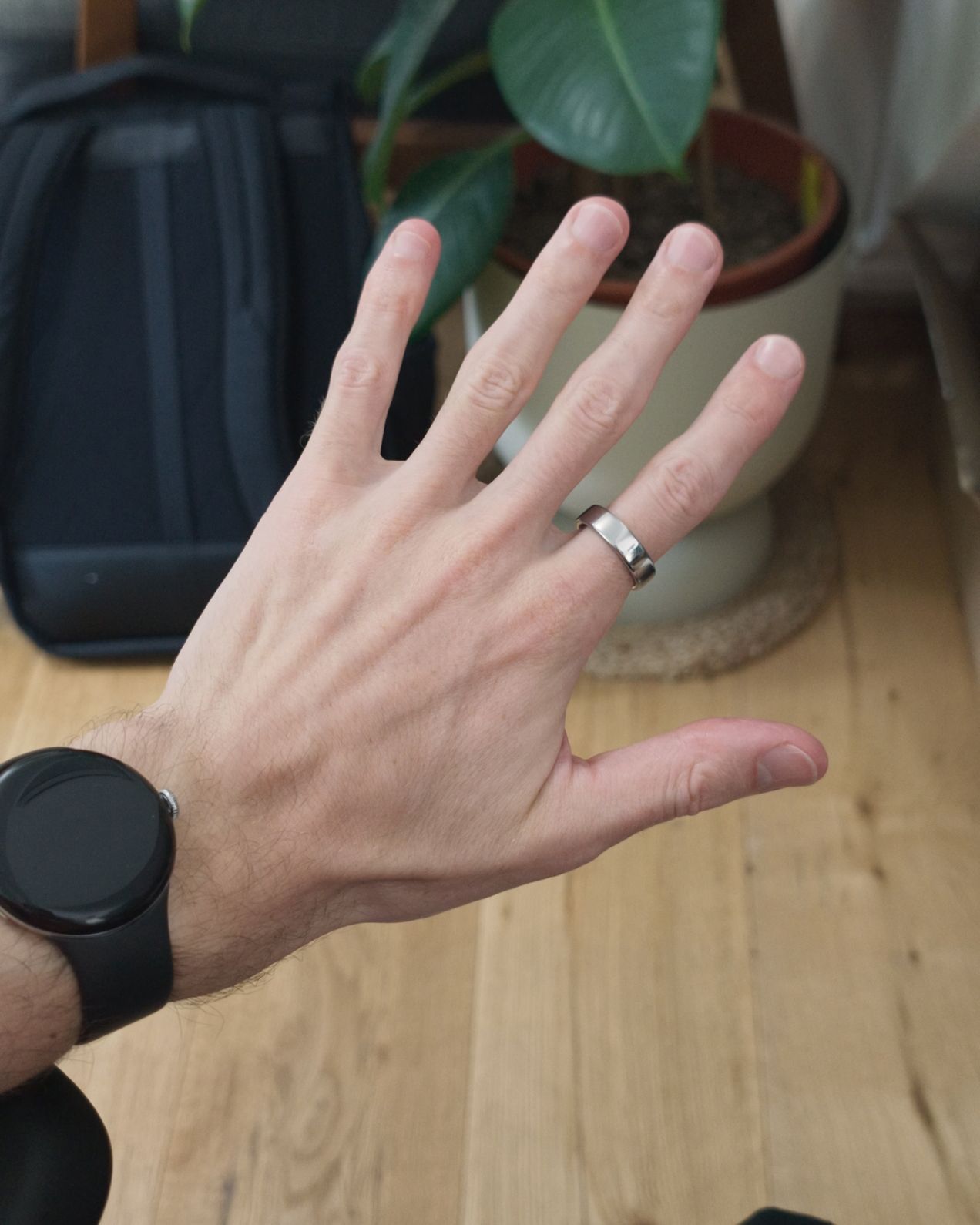 A hand wearing a watch and a silver ring
