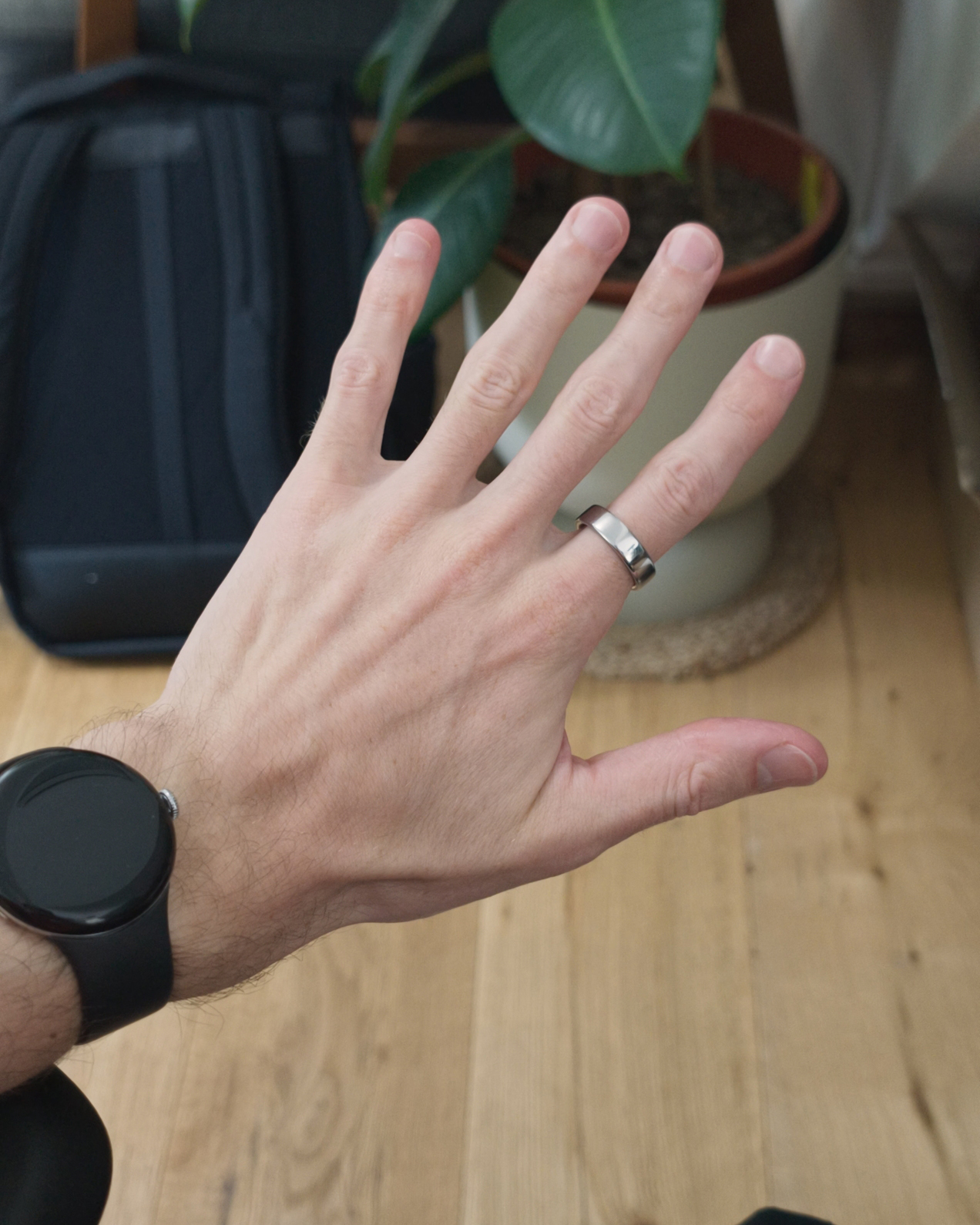 A hand wearing a watch and a silver ring