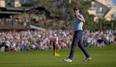 Justin Rose waves to the fans after holing a putt