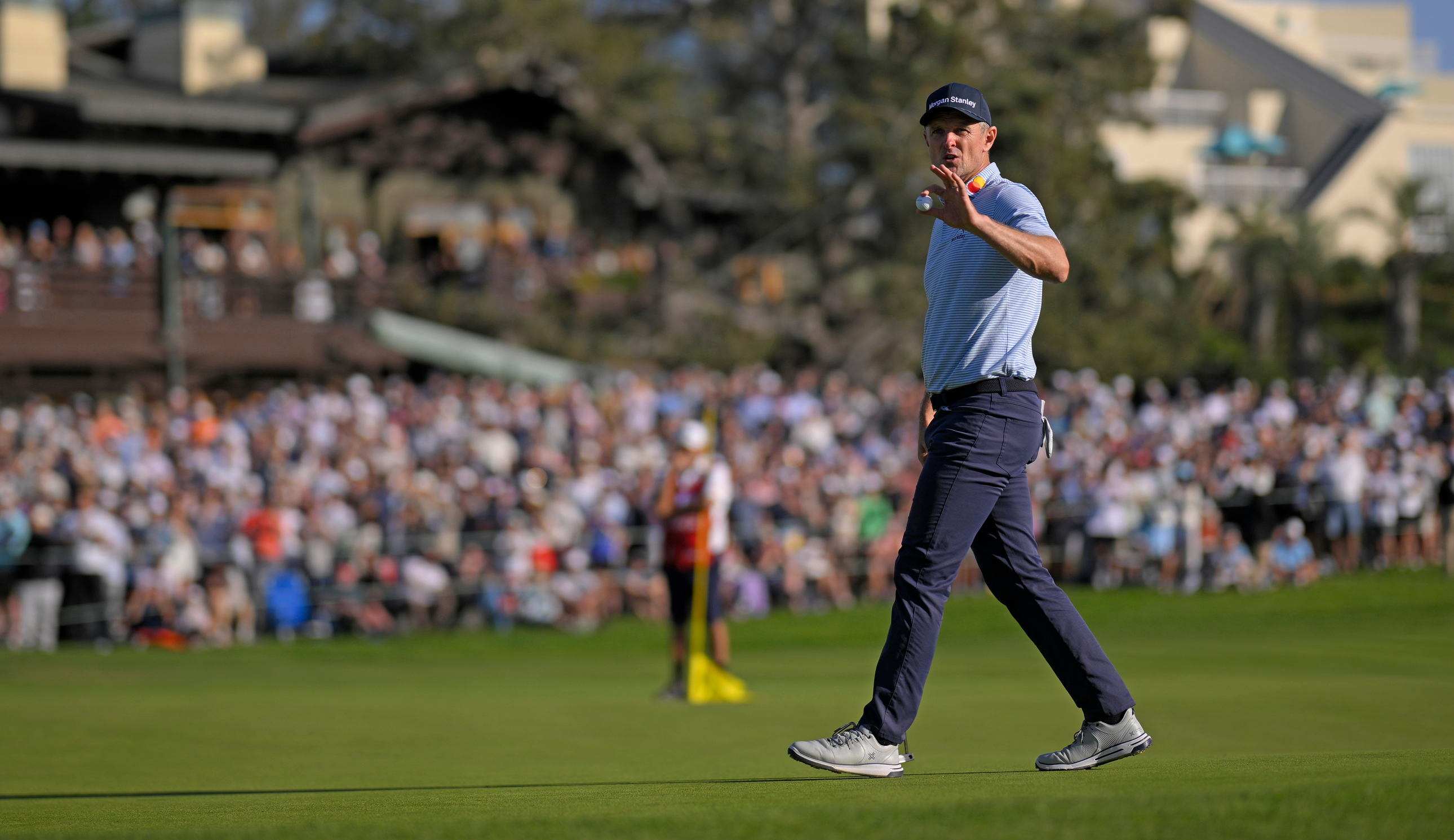 Justin Rose waves to the fans after holing a putt