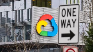 A view of a Google Cloud logo on a building, with a one way sign displayed next to it