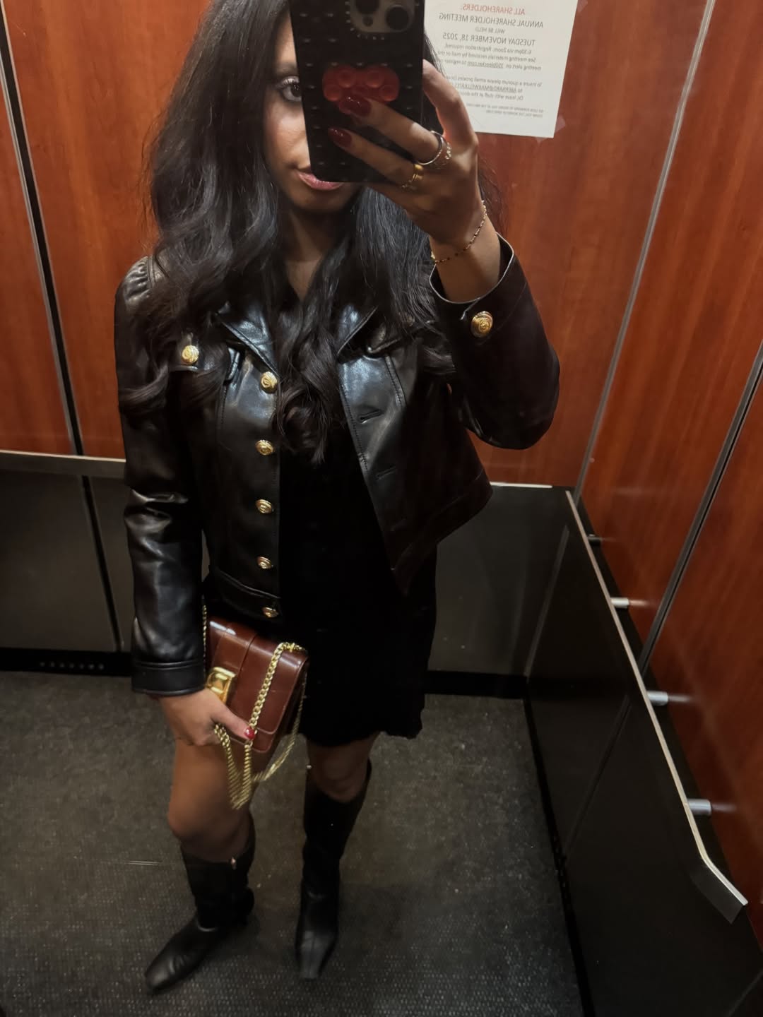 A woman wears a warm brown bag with a leather jacket.