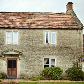 house exterior with white windows and wooden door
