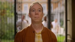 Kevin Sussman in a yellow checked shirt and orange jacket looking serious in Stuart Fails To Save The Universe.