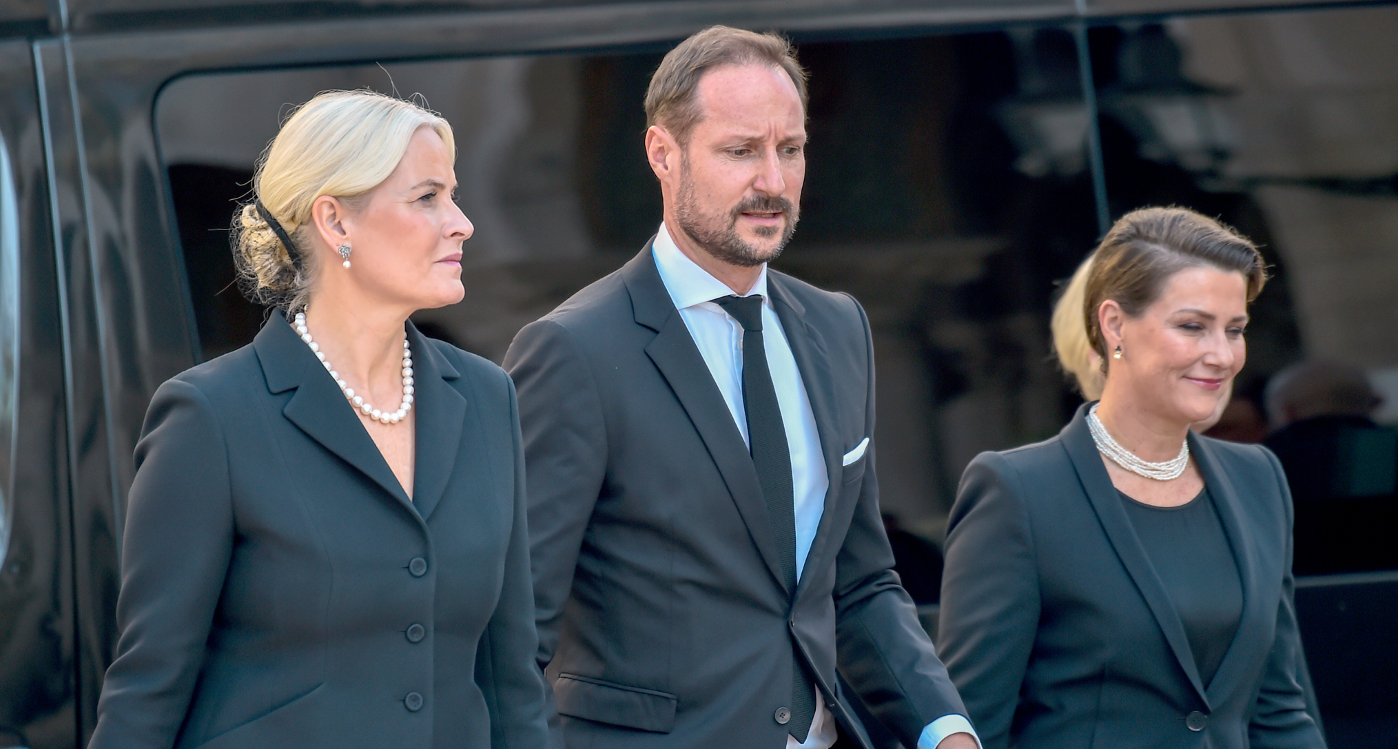 Crown Princess Mette-Marit, Crown Prince Haakon, Princess Martha Louise wearing black walking in a line