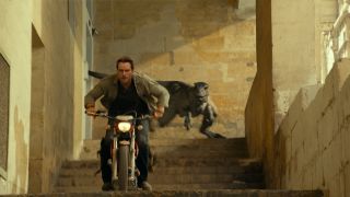Chris Pratt riding away from an Atrociraptor on a motorcycle in Jurassic World Dominion.