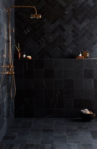 a bathroom with black tiles and black grouting
