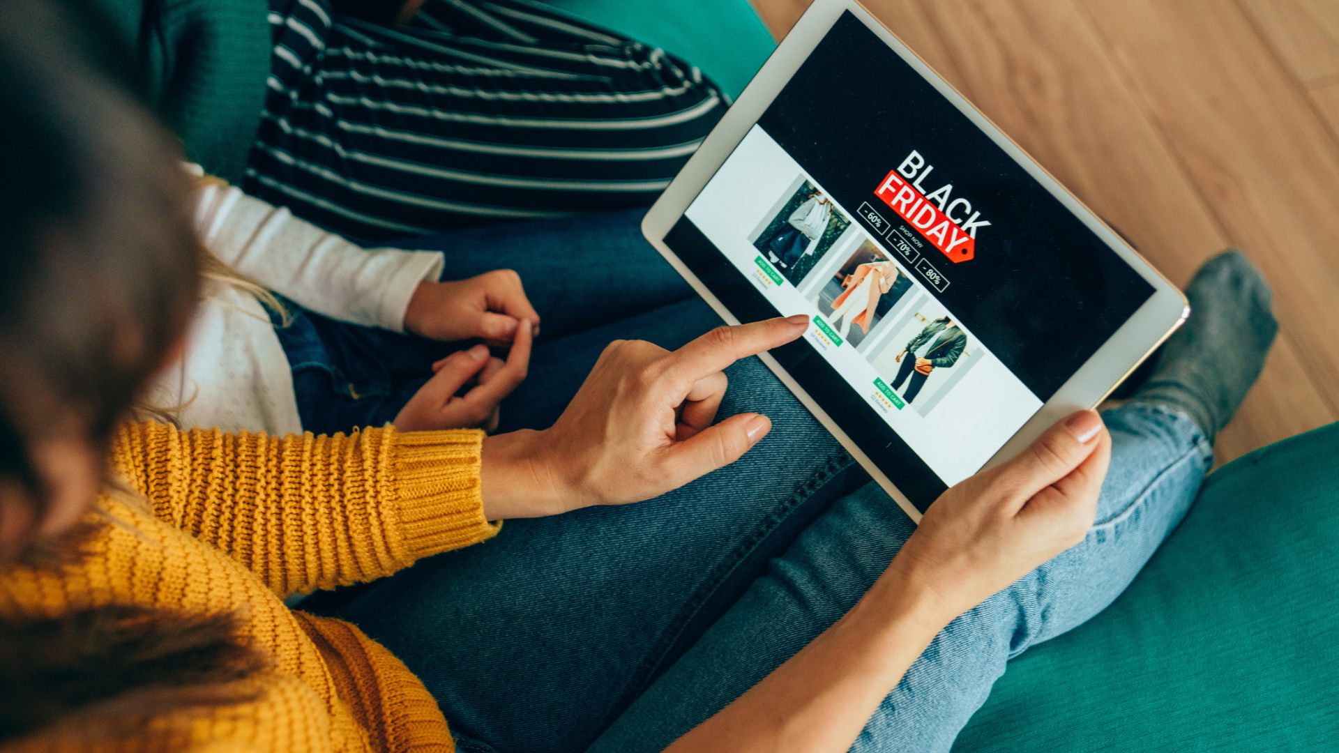 Young woman sitting on the sofa with her family and shopping online with digital tablet.