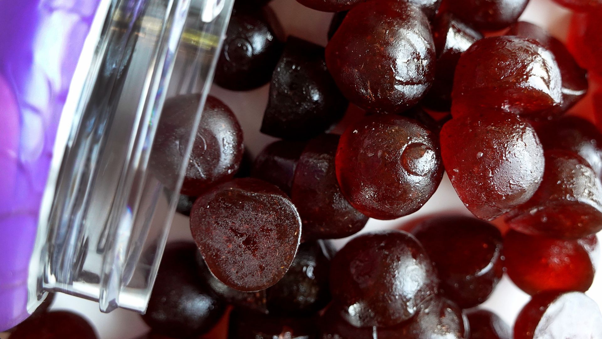 A close-up of a spilled jar full of strawberry-flavored melatonin gummies for sleep.