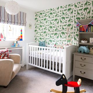 nursery with animal print wall and cradle and arm chair