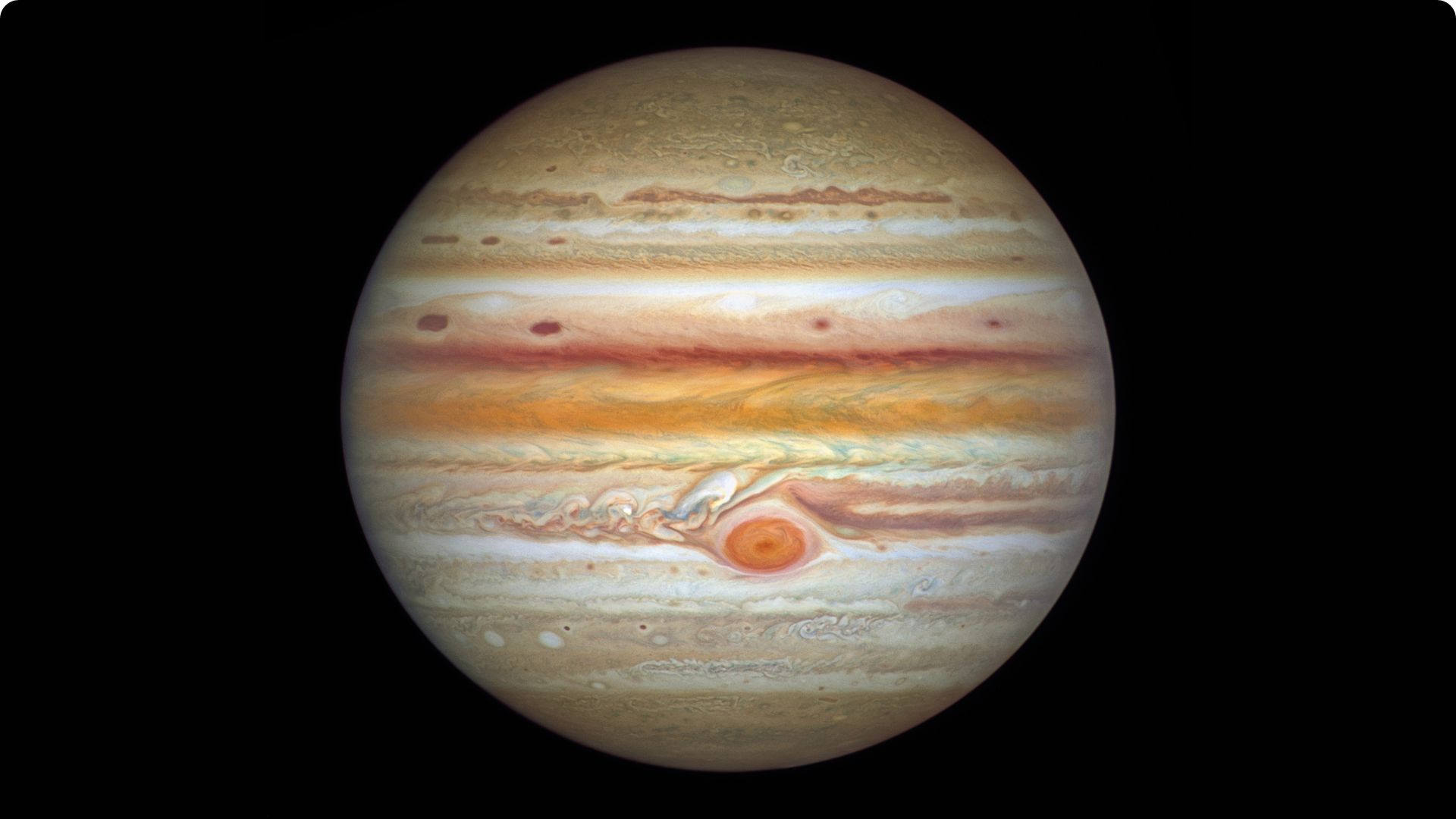 The gas giant Jupiter is pictured against a black background in an image captured by the Hubble Space Telescope. Multi-coloured cloud bands and storms are visible on its surface, as is the Great Red Spot.