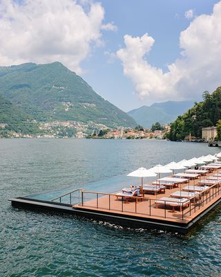 rows of loungers and umbrellas at Mandarin Oriental floating infinity pool platform by Herzog and de Meuron