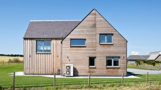 a timber clad self build home with an air source heat pump