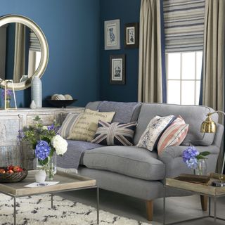 blue living room with grey sofa and mirror