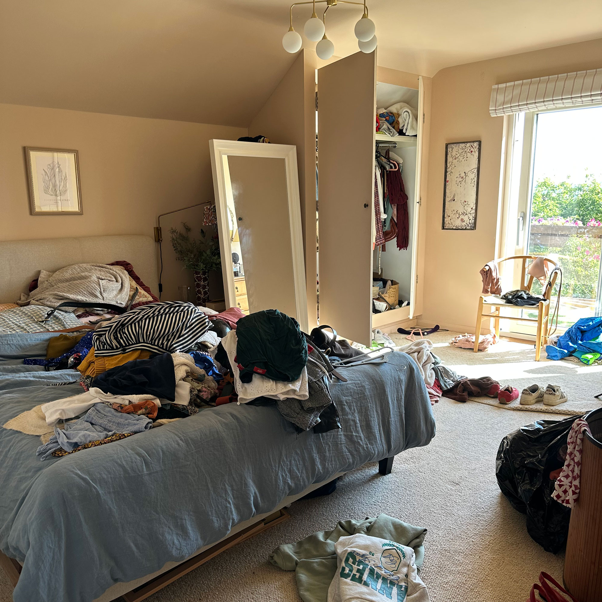 Bedroom with piles of clothes ready for decluttering