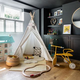 Black boys bedroom playroom with teepee tent, white shutters, built-in shelving